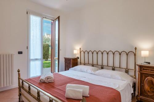 una camera con un grande letto e una grande finestra di Casa BELLA - POOL Garden Parking a Polpenazze del Garda