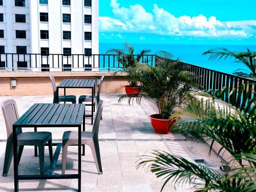 a patio with two tables and chairs and the ocean at 东方酒店 in Sihanoukville