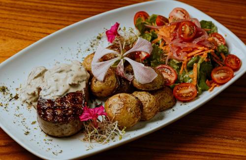 a plate of food with potatoes and vegetables on a table at Hotel Tres Banderas in Manuel Antonio
