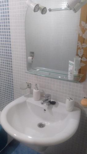 y baño con lavabo blanco y espejo. en Catoira apto vacacional, en Catoira