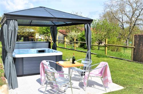 una mesa de picnic y sillas bajo una sombrilla negra en Le Cémarose: spa, jardin, terrasse et jolie vue au cœur d'Epernay, en Épernay