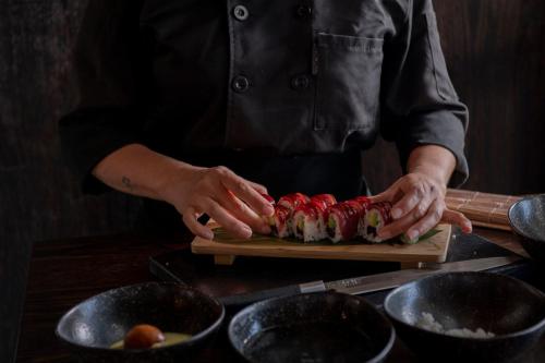 a person preparing food on a cutting board at Hotel El Pilar Andalucia in Estepona