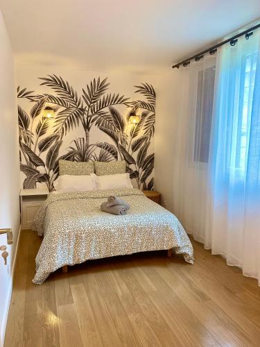 - une chambre avec un lit et une grande plante sur le mur dans l'établissement Sweet apartment near Paris Center, à Vitry-sur-Seine