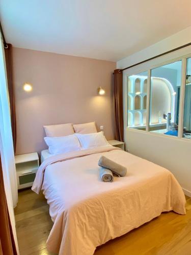 une chambre avec un grand lit avec une grande fenêtre dans l'établissement Sweet apartment near Paris Center, à Vitry-sur-Seine