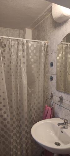 a bathroom with a sink and a shower curtain at Apartman Branka in Omiš