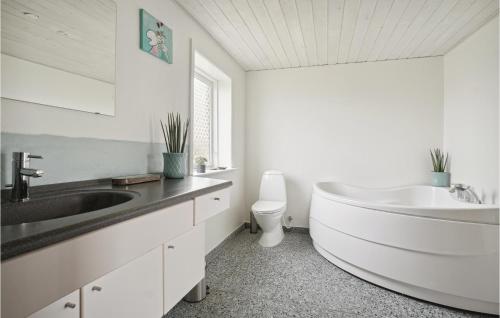 uma casa de banho com uma grande banheira branca e um lavatório. em Gorgeous Home In Snedsted With House A Panoramic View em Snedsted