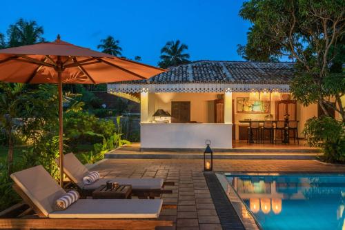 een villa met een zwembad en een huis bij Ceylo Villas in Bentota
