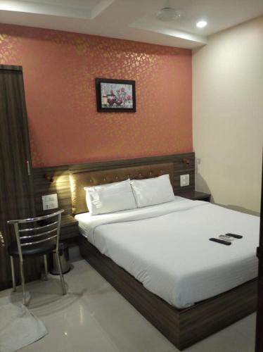 1 dormitorio con 1 cama grande y pared roja en Orange International-SANTACRUZ, en Bombay