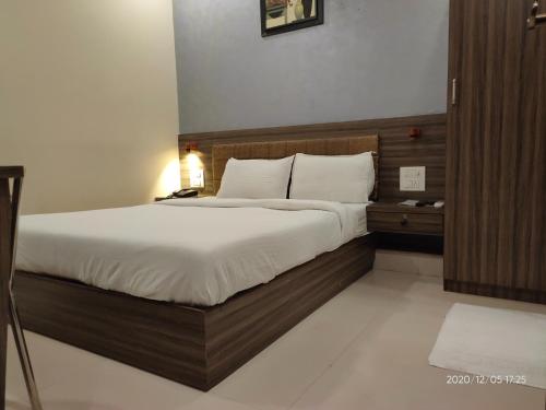 1 dormitorio con 1 cama grande con sábanas blancas en Orange International-SANTACRUZ, en Bombay