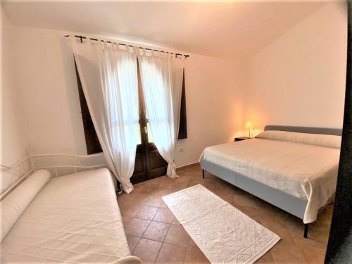 - une chambre avec 2 lits et une fenêtre dans l'établissement Casa Luisa IUN Q3032 Appartamento a 5 minuti in macchina dal Mare, à Bari Sardo