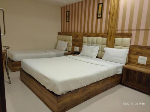 a bedroom with two beds with white sheets at Orange International-SANTACRUZ in Mumbai