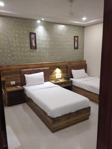 a bedroom with two beds and a green wall at Orange International-SANTACRUZ in Mumbai