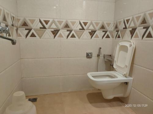 a bathroom with a white toilet in a room at Orange International-SANTACRUZ in Mumbai