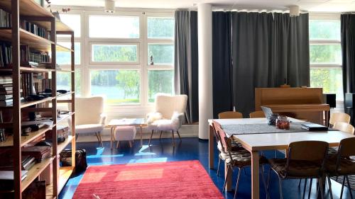 een kamer met een tafel, stoelen en ramen bij Vanha Koulu in Suolahti
