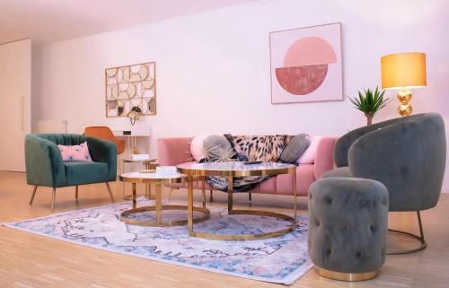 a living room with a pink couch and chairs at R213 Residences Botanique in Brussels