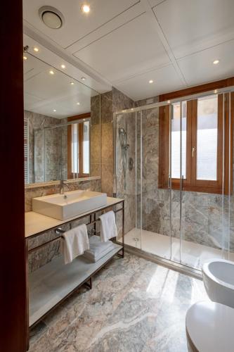 a bathroom with a tub and a sink and a shower at Palazzina Fortuny in Venice