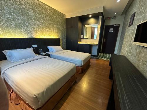 a hotel room with two beds and a mirror at Fajar Hotel in Lahad Datu