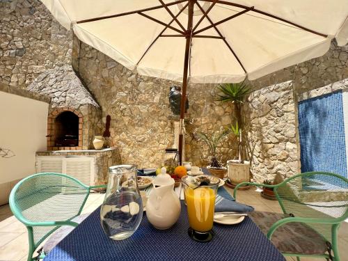 a table with an umbrella and some drinks on it at Central Tavira Townhouse close to Riverside: 2BR in Tavira