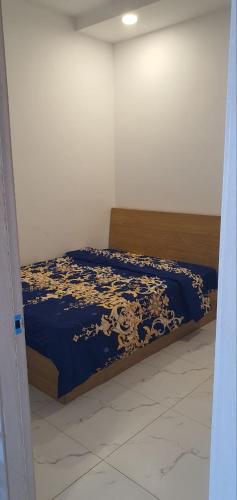 a bedroom with a bed with a blue and gold blanket at Residence L two bedroom in Phnom Penh