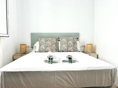 una camera da letto con un grande letto bianco con due piatti sopra di Hispalis Plaza de Santa Cruz a Siviglia