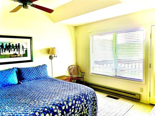 a bedroom with a blue bed and a window at TALISMAN AMAZING VIEWS Walk to Uptown Sleeps 4 in Pagosa Springs