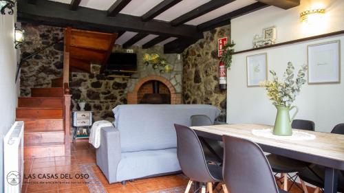 uma sala de jantar com uma mesa e um sofá em La Seronda de Villaorille - Las Casas del Oso 