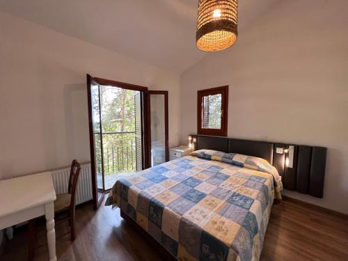 a bedroom with a bed and a table and a window at POED Residences in Platres