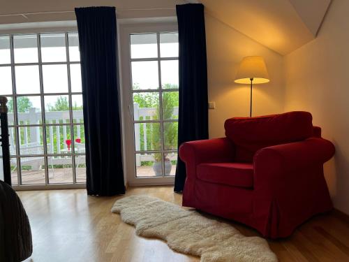 a living room with a red chair and a lamp at Villa Sofia Boutique Trakai in Trakai