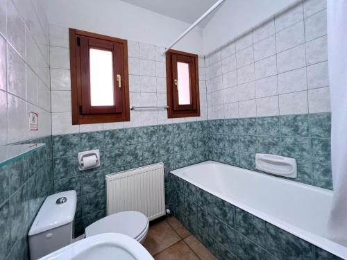 a bathroom with a tub and a toilet and a sink at POED Residences in Platres