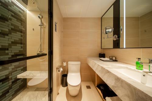 a bathroom with a toilet and a sink and a shower at Fairfield by Marriott Harbin Downtown in Harbin