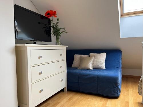 a blue couch with a tv on top of a dresser at Villa Sofia Boutique Trakai in Trakai