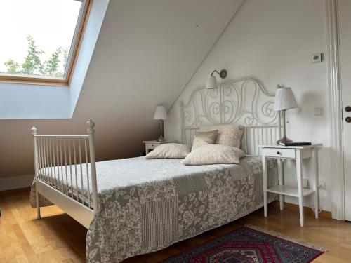 a bedroom with a bed with a white bed frame and a window at Villa Sofia Boutique Trakai in Trakai