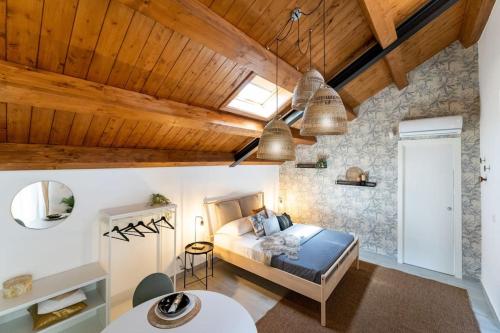 維亞格蘭德的住宿－Baglio Delle Terre Nere - Affitti Brevi Italia，一间卧室设有床铺和木制天花板