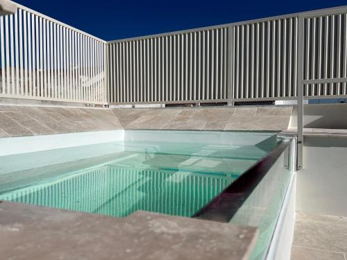 a swimming pool with a wooden fence around it at Arcos de Medina - Apartamentos premium in Córdoba