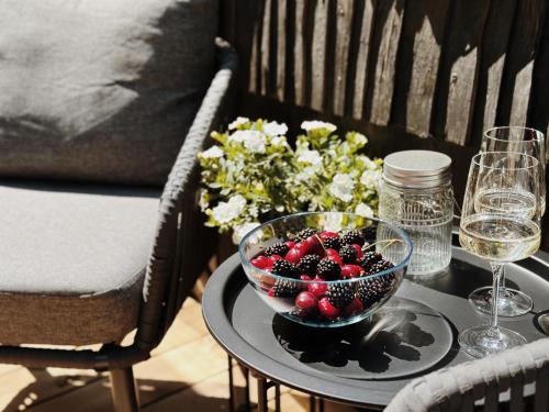 uma taça de fruta numa mesa com copos de vinho e flores em Pedaspä Igloo House and Sauna em Pedaspea