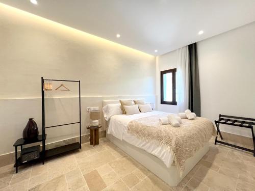 a bedroom with a large white bed and a window at Arcos de Medina - Apartamentos premium in Córdoba