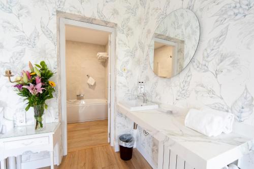 a bathroom with a sink and a mirror at Infanta Isabel by Recordis Hotels in Segovia