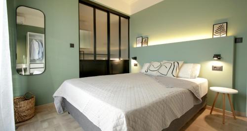 een slaapkamer met een wit bed en een spiegel bij Onos - 2 bedroom 2 bathroom penthouse with terrace in Old Town in Kalamata