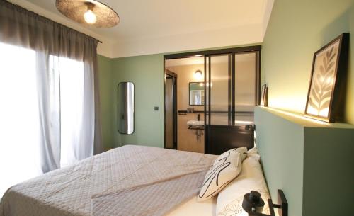 een slaapkamer met groene muren, een bed en een raam bij Onos - 2 bedroom 2 bathroom penthouse with terrace in Old Town in Kalamata