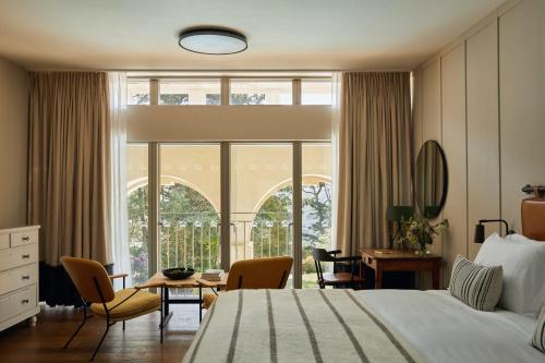 a bedroom with a bed and a table and chairs at Fowey Hall Hotel in Fowey