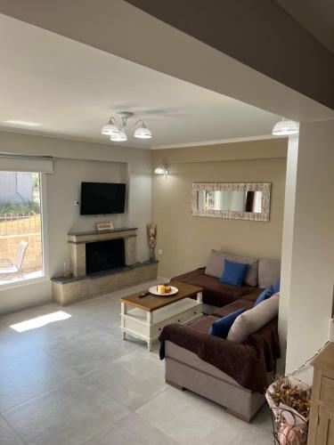 un soggiorno con divano e TV di Faidra's House a Città di Lefkada