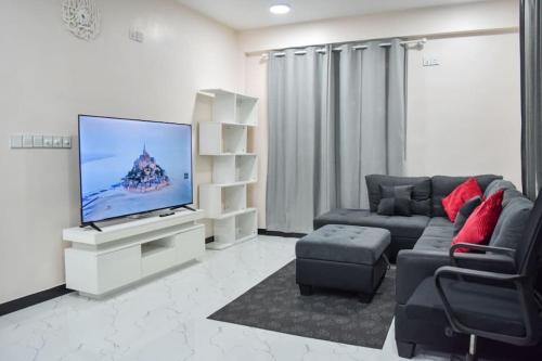 a living room with a couch and a flat screen tv at EQUATOR RETREAT in Fuvahmulah