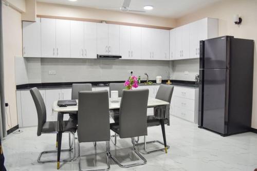 La cuisine est équipée d'une table, de chaises et d'un réfrigérateur. dans l'établissement EQUATOR RETREAT, à Fuvahmulah