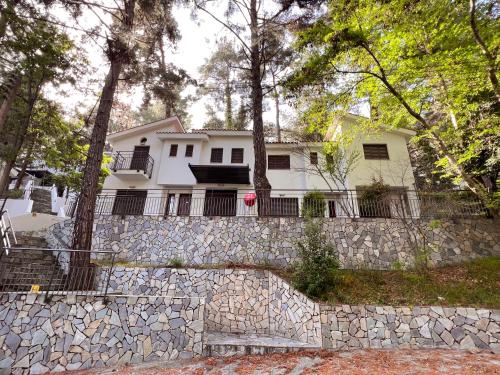 a white house behind a stone wall at POED Residences in Platres