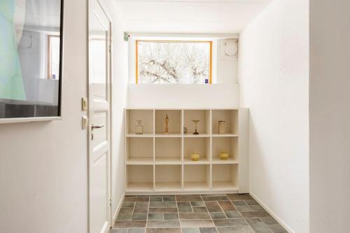 un couloir avec une porte blanche et une fenêtre dans l'établissement Lägenhet i ett hus egen ingång, à Sundbyberg