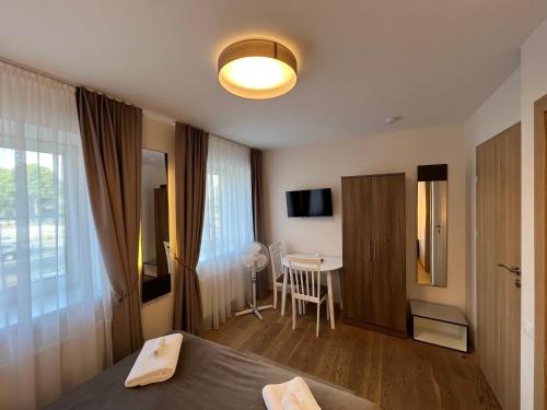 a hotel room with a bed and a table with a chair at 1912 Bed & Breakfast in Klaipėda