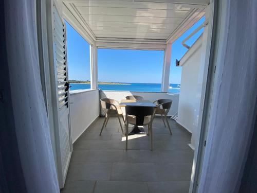 a balcony with a table and chairs and the ocean at Emanuela 1 in Novalja