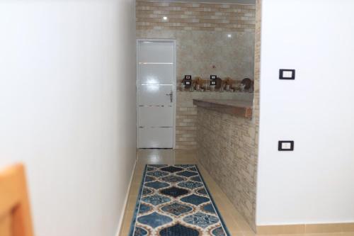 um corredor com uma cozinha com um frigorífico e um tapete em Royal Mountain em Luxor