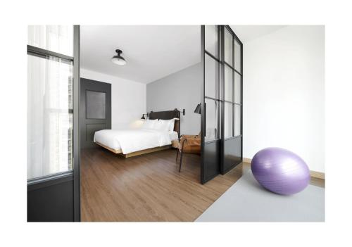 a room with a bed and a large mirror at Moxy Shenzhen North Station in Shenzhen