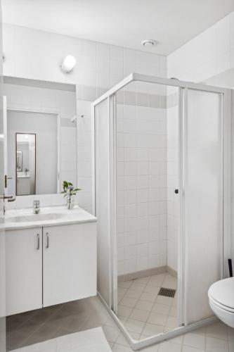 a bathroom with a shower and a sink and a toilet at Hotel Pinenhus in Glyngøre